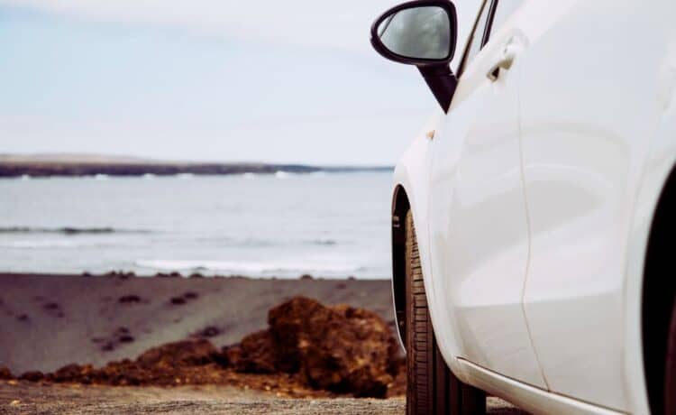 A white car parked by the beach