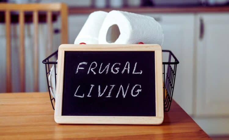 A frugal living sign with a basket of toilet paper behind it